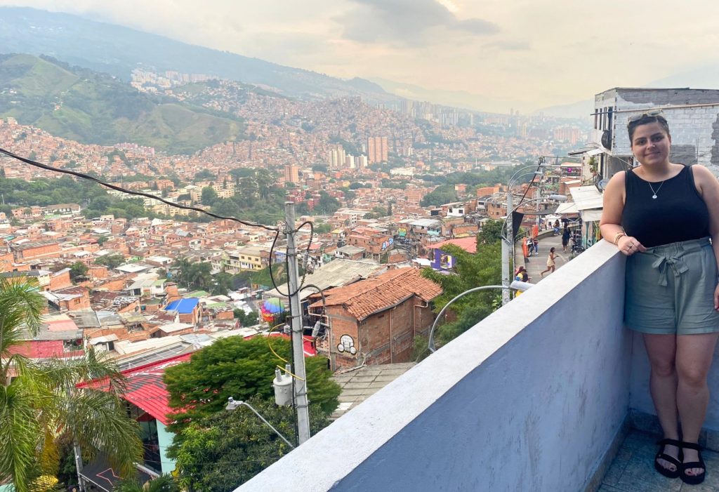 Woman standing on balcony overlooking Comuna 13 in Colombia