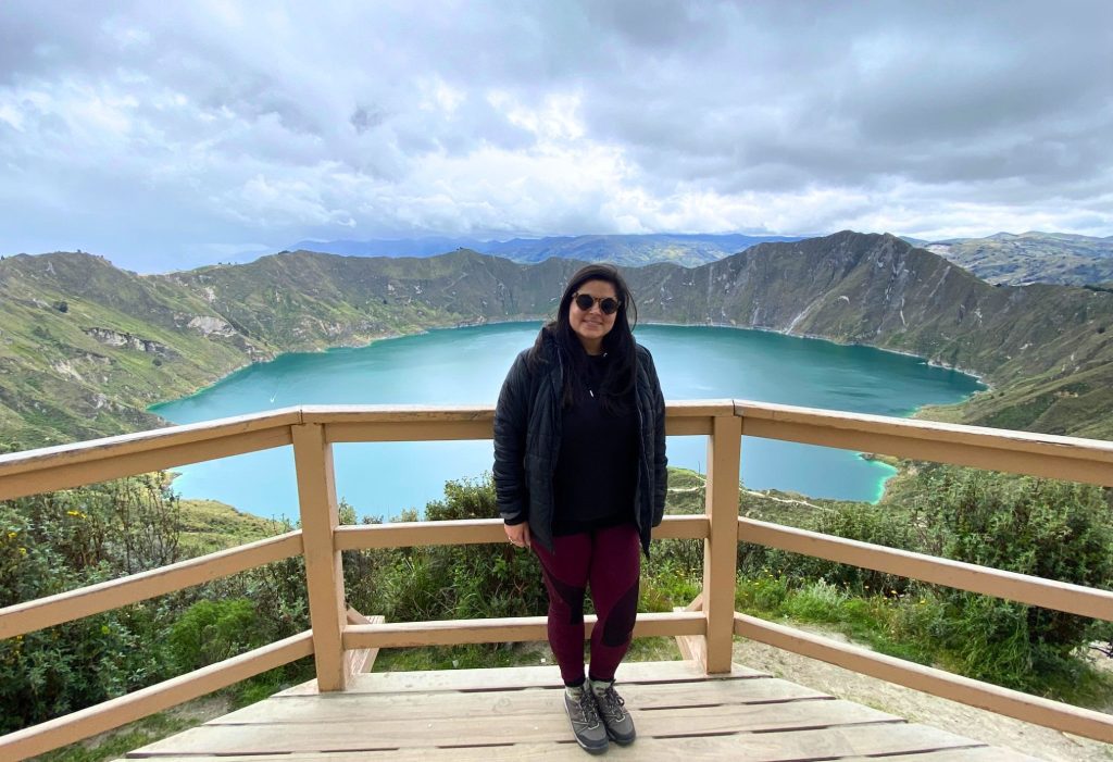 Woman standing on a viewing platform overlooking Quilotoa Lake in Ecuador
